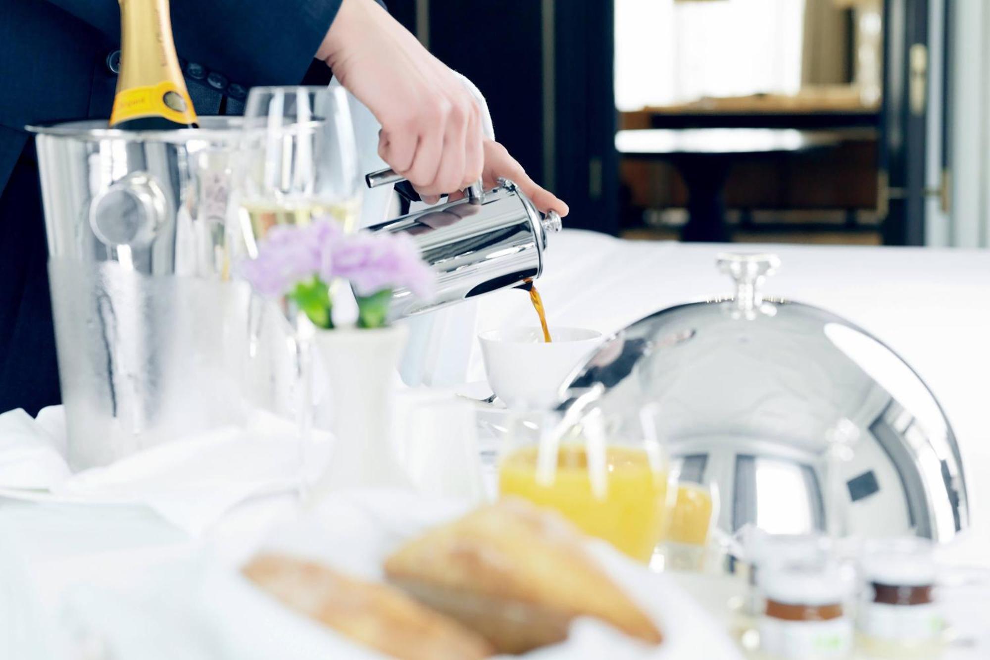 The St. Regis Astana Hotel Exterior photo A server pouring orange juice